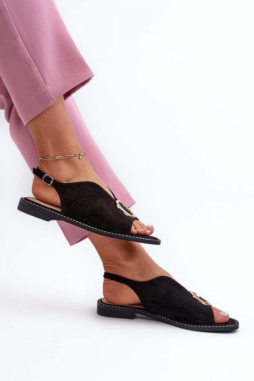 Woman wearing Veralya suede sandals with gold accent and adjustable ankle straps.