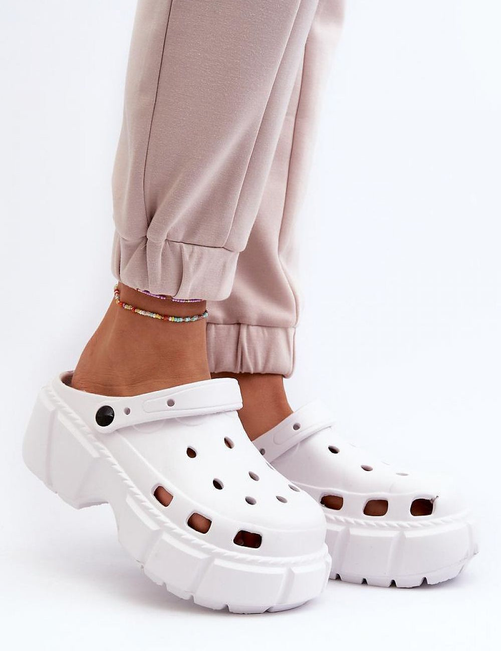 Person wearing white Delvyna Sculpted Foam Beach Slides with thick sole, on a white background.