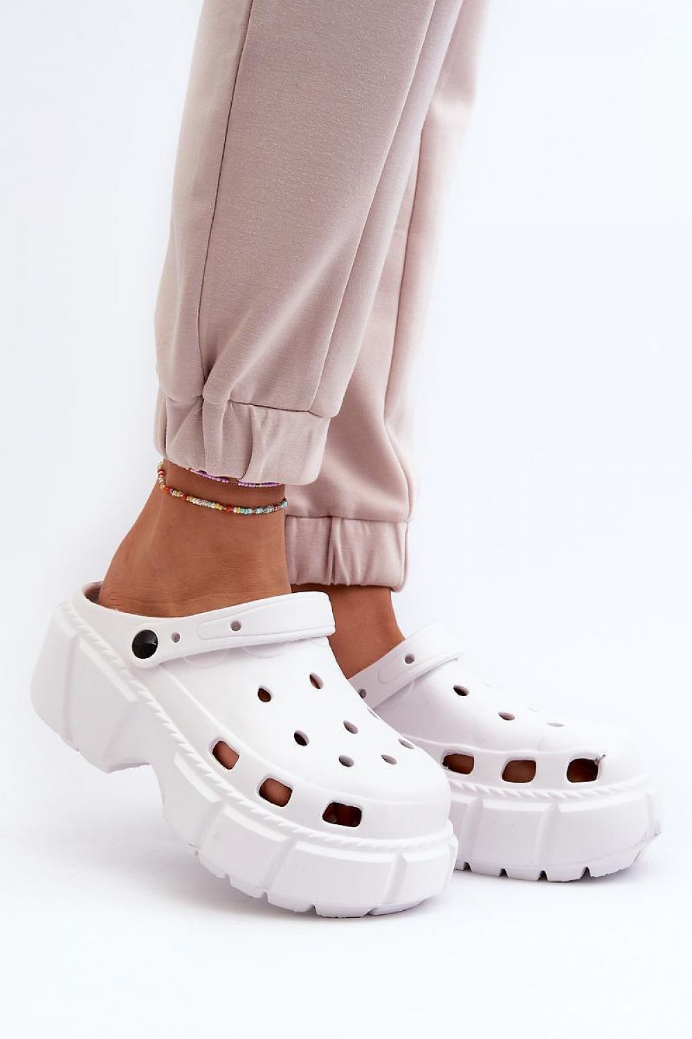 Person wearing white Delvyna Sculpted Foam Beach Slides with thick sole, on a white background.