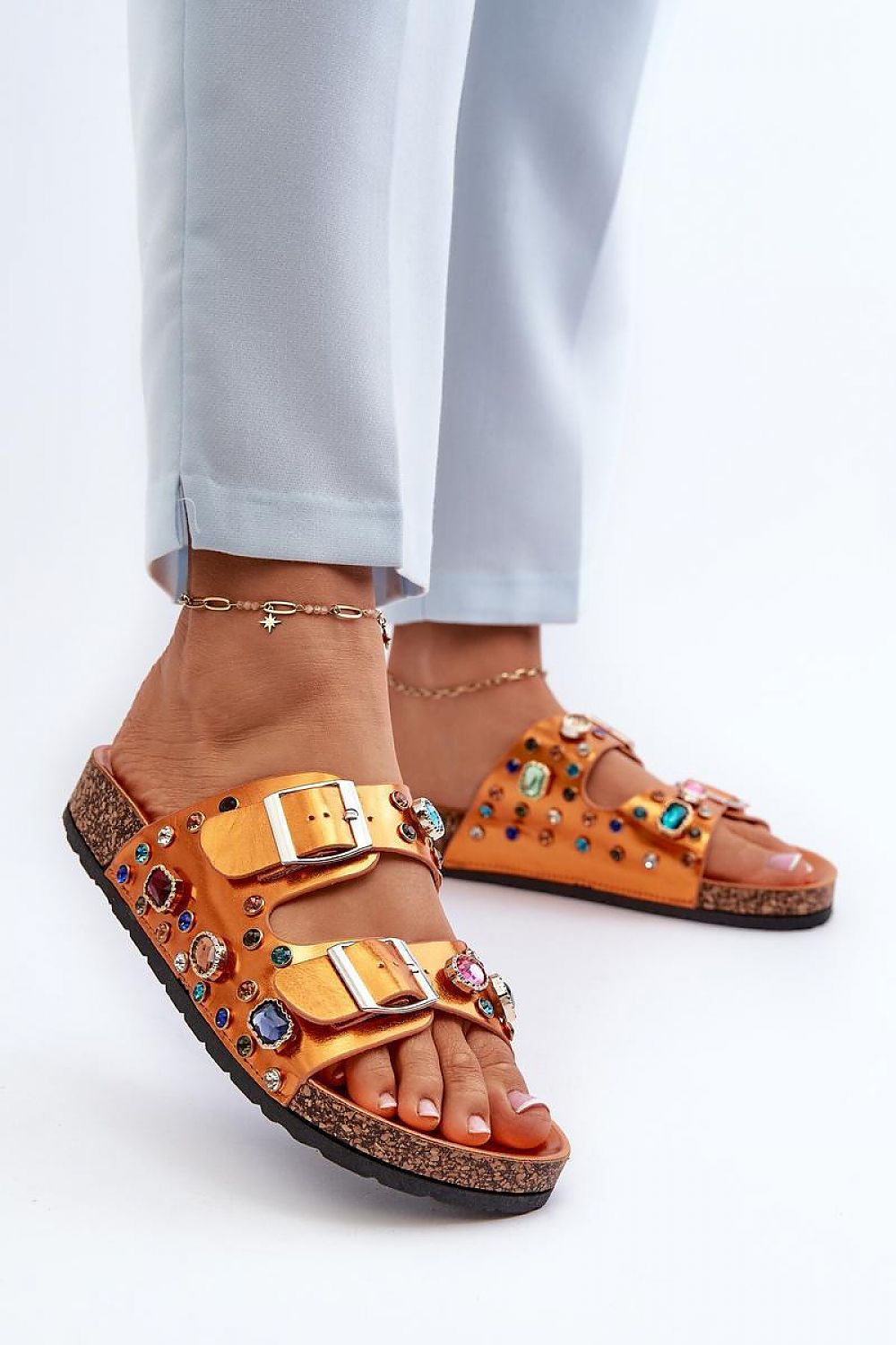 Woman wearing Merelina Crystal Buckle Platform Slides with crystal embellishments and adjustable buckles, showcasing eco leather and cork-inspired platform.