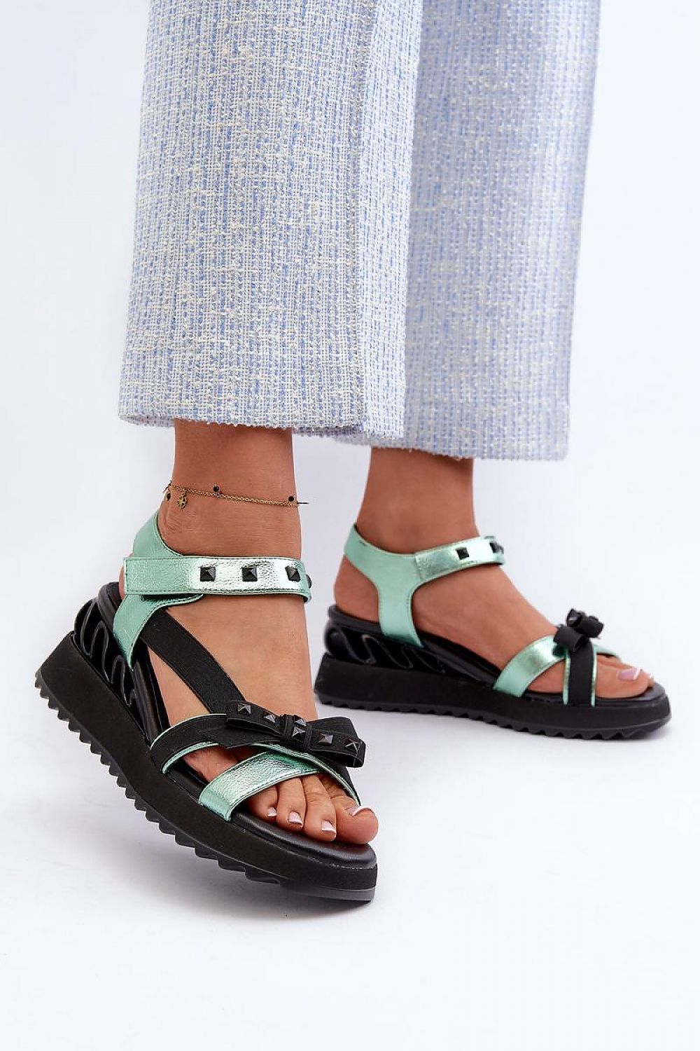 Woman wearing Aurelline Strap Bow Wedge Sandals with artificial leather, delicate bow detail, and Velcro strap for easy closure.