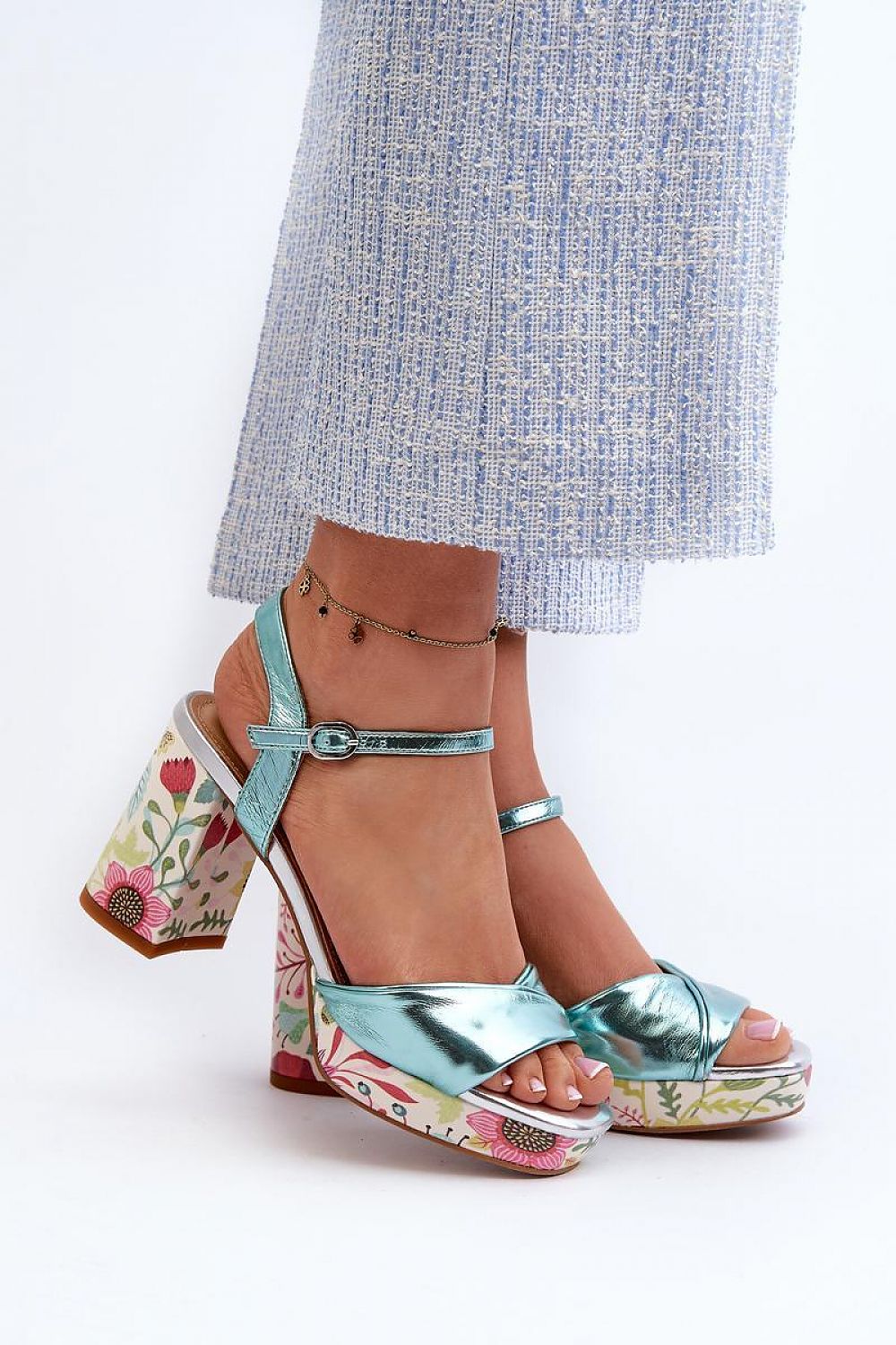 Florvella Patterned Block Heel Sandals with floral design and adjustable buckle strap worn with blue pants.
