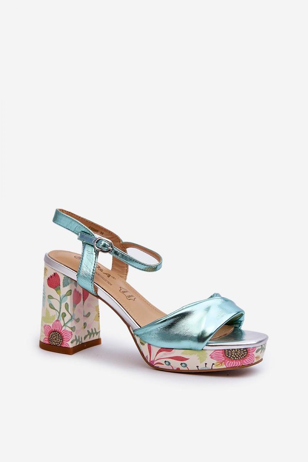 Florvella patterned block heel sandal in metallic blue with floral design, featuring buckle strap and artificial leather upper.