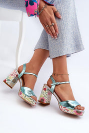 Florvella Patterned Block Heel Sandals with floral design, artificial leather upper, block heel, adjustable buckle strap, shown on model.
