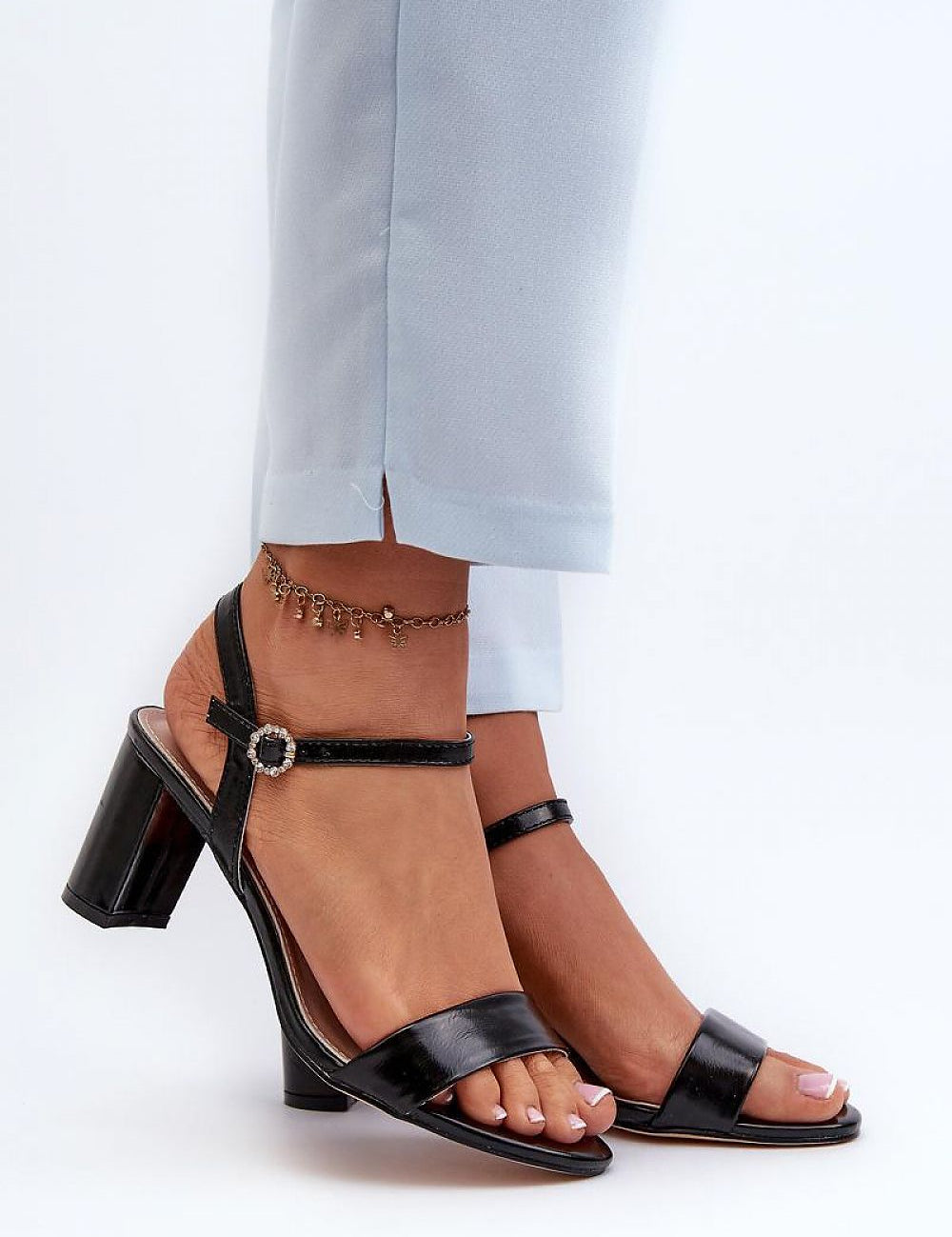 Woman wearing Zarellia Metallic Strap Post Heel Sandals with decorative buckle and eco leather upper, showcasing elegance and comfort.