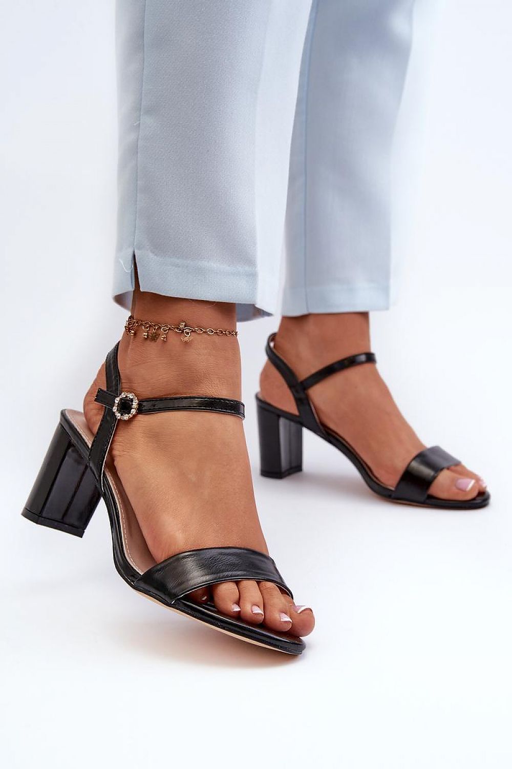 Zarellia metallic strap post heel sandals with eco leather upper and decorative buckle, worn on a model with light trousers.