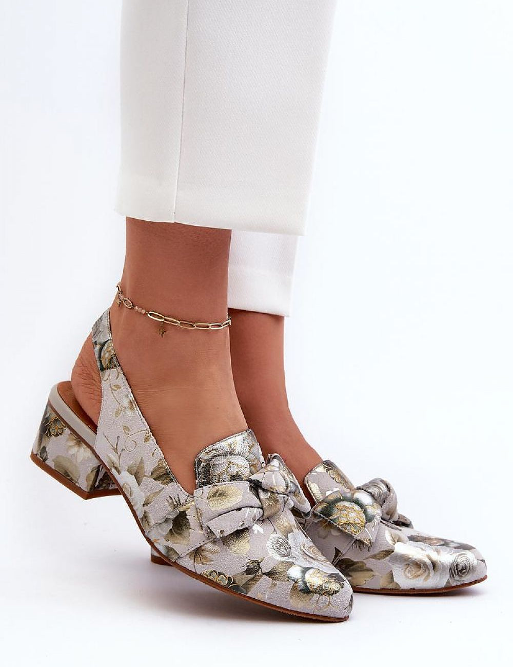 Woman wearing Elviera Floral Leather Heel Sandals with subtle floral pattern and ankle strap for a romantic, elevated look.