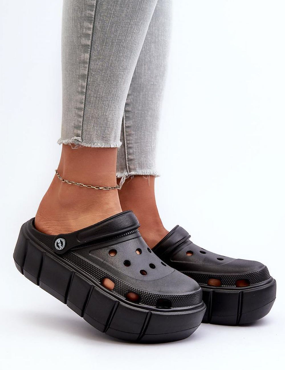 Rivaya Sculpted Foam Slides with platform design, worn with jeans, showcasing bold lines, cushioned foam for comfort and style.