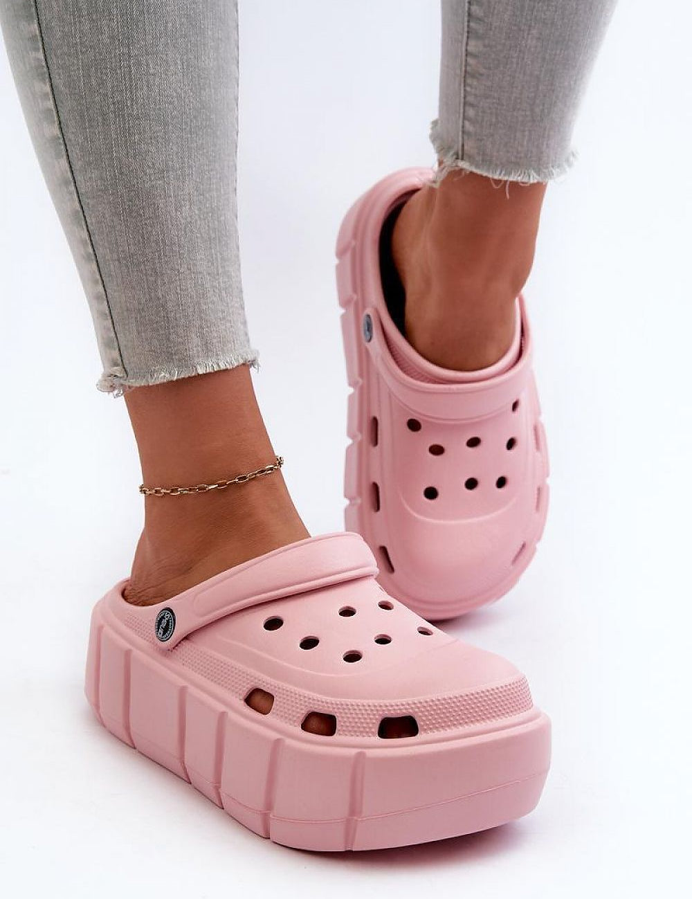 Pink Rivaya Sculpted Foam Slides with platform sole, worn with jeans, featuring lightweight foam construction and cushioned comfort.