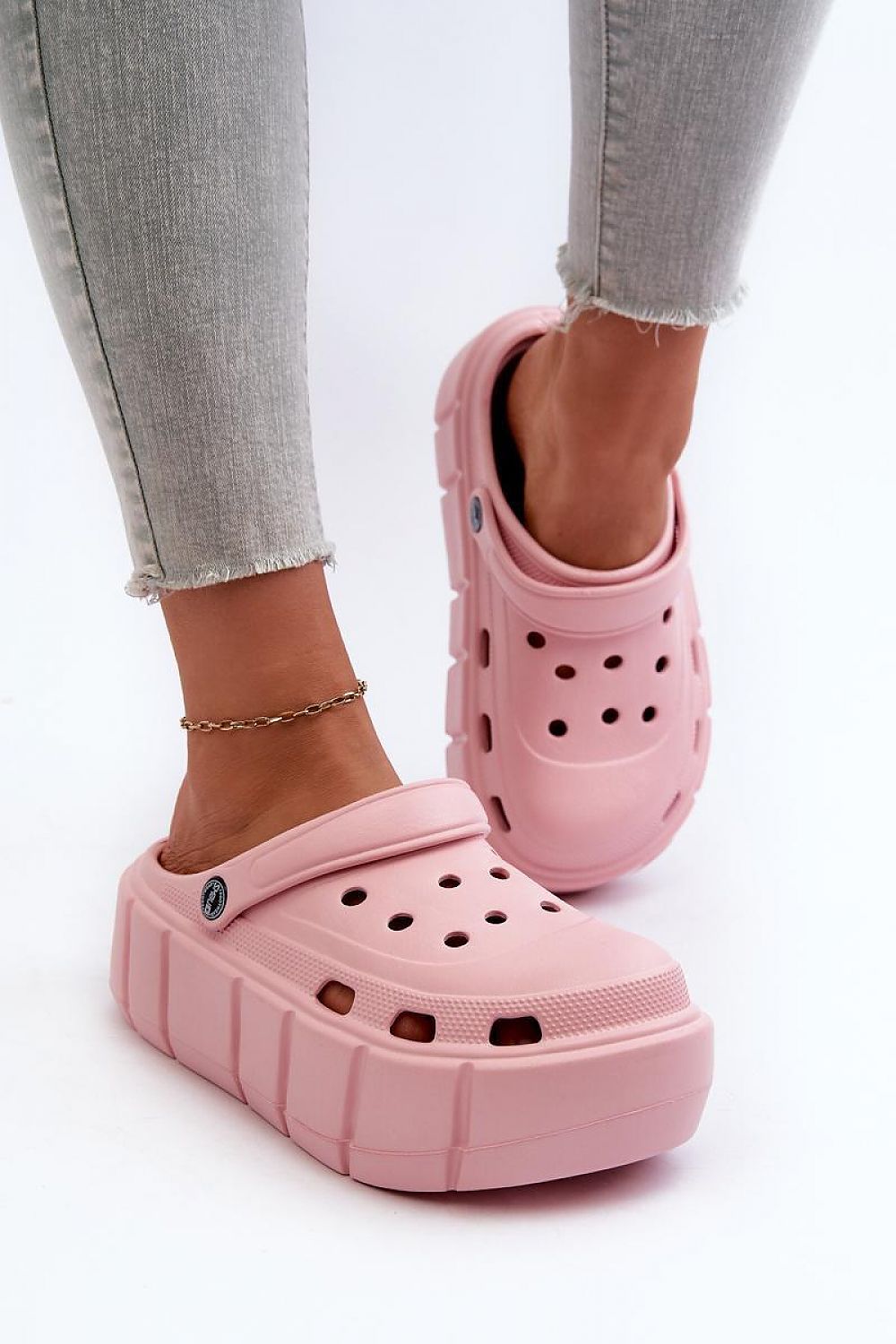 Pink Rivaya Sculpted Foam Slides with platform sole, worn with jeans, featuring lightweight foam construction and cushioned comfort.