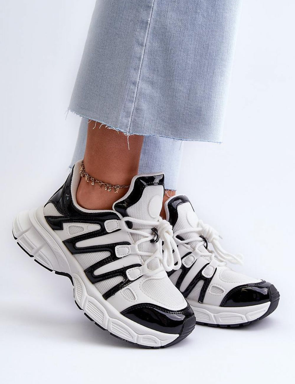 Astaria thick-soled street sneakers in black and white with soft removable insoles, styled with casual jeans for an urban look.