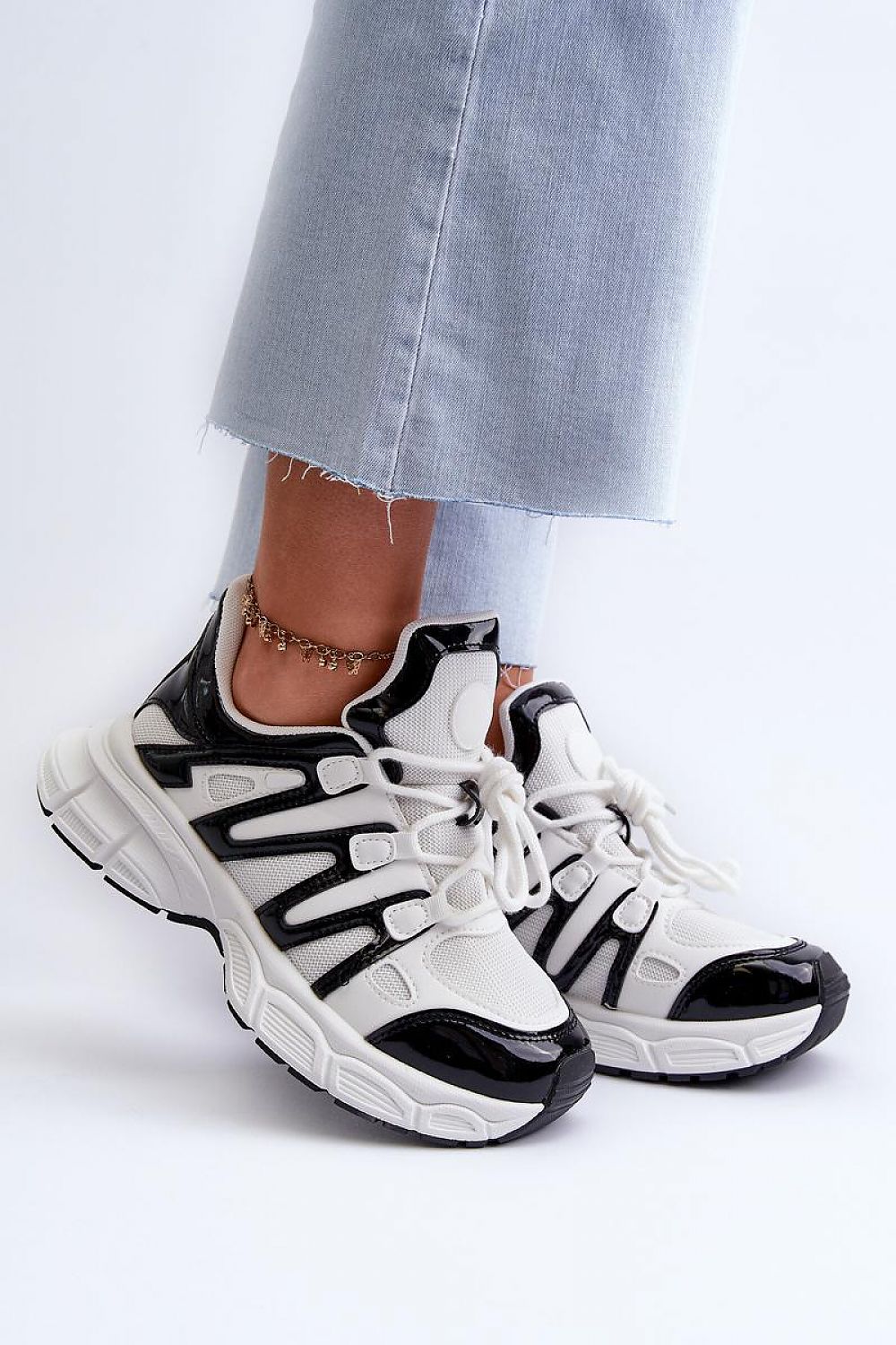 Astaria thick-soled street sneakers in black and white with soft removable insoles, styled with casual jeans for an urban look.
