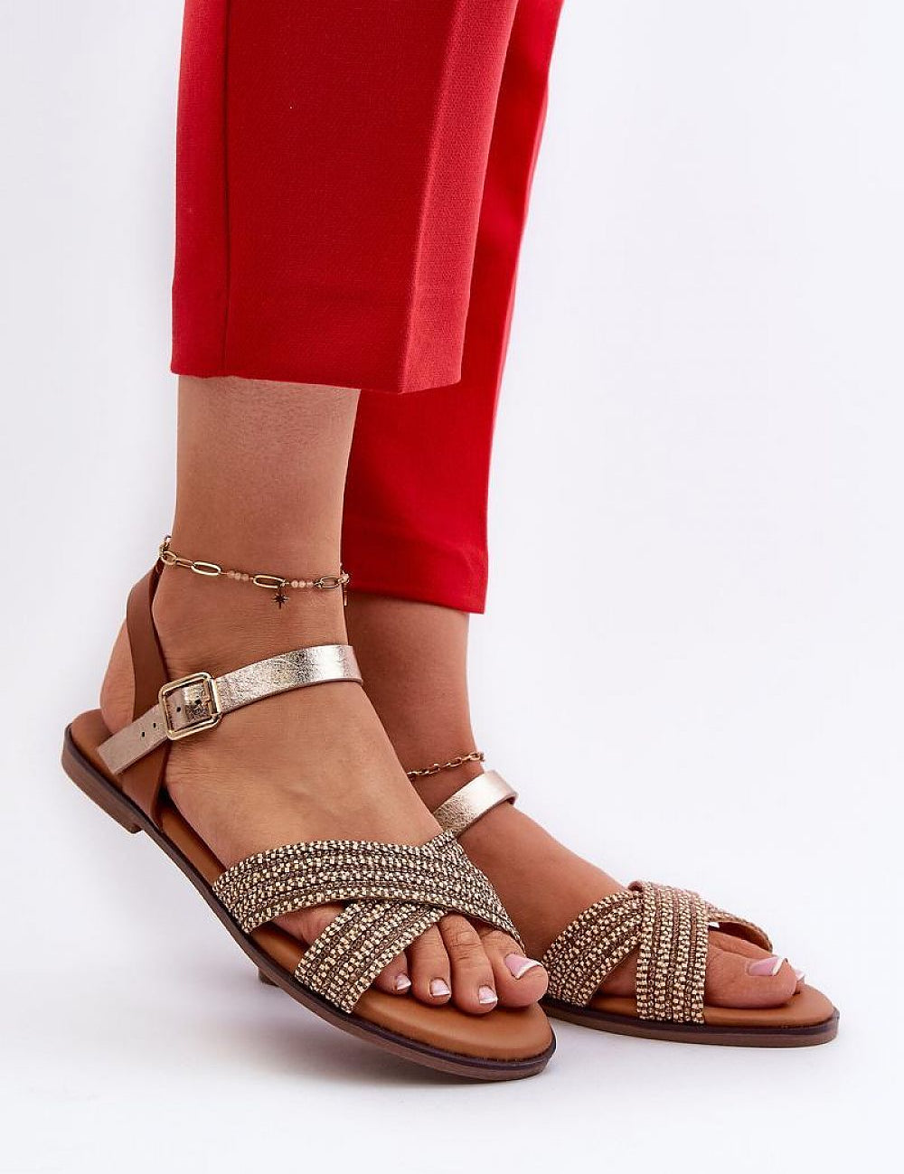 Woman modeling Serelvia Minimal Strap Sandals with eco leather, adjustable buckle, and flat sole paired with red pants.