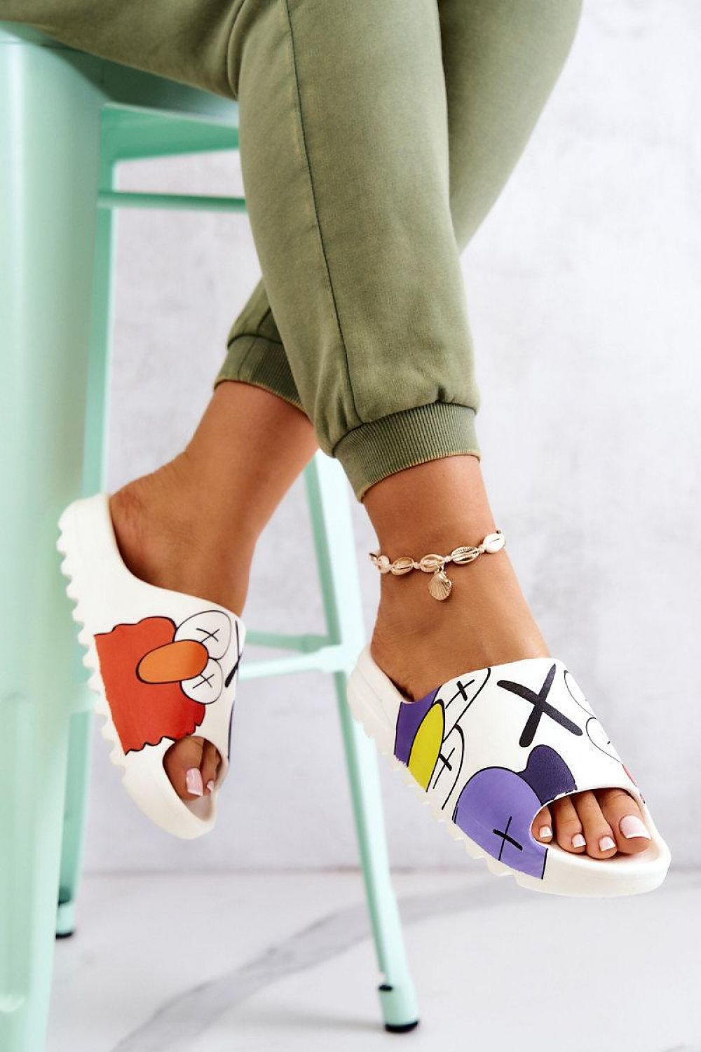 Cartoon-inspired rubber summer slides with playful print on a woman's foot, showcasing a fun and colorful design, worn indoors.
