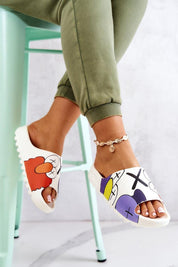 Cartoon-inspired rubber summer slides with playful print on a woman's foot, showcasing a fun and colorful design, worn indoors.