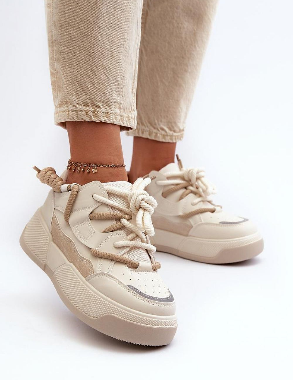 Velenta modern platform sneakers in beige, featuring smooth artificial leather uppers, worn with casual pants for a stylish look.