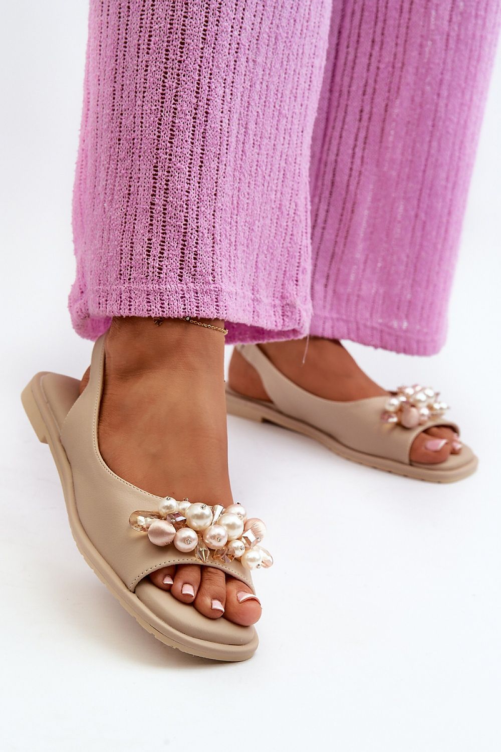 Rensola minimalist flat sandals with pearl accents and eco leather, worn with pink pants; elegant and secure elastic back strap.