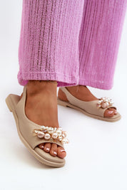 Rensola minimalist flat sandals with pearl accents and eco leather, worn with pink pants; elegant and secure elastic back strap.