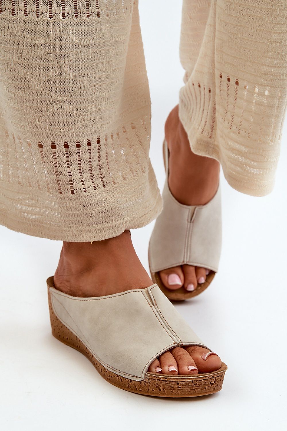 Woman wearing Solenca Soft Arch Flip-Flops with faux leather and suede insole, paired with beige crochet pants.
