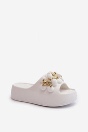White platform flip-flop with decorative embellishments and thick sole, ideal for casual summer wear and beach outings.