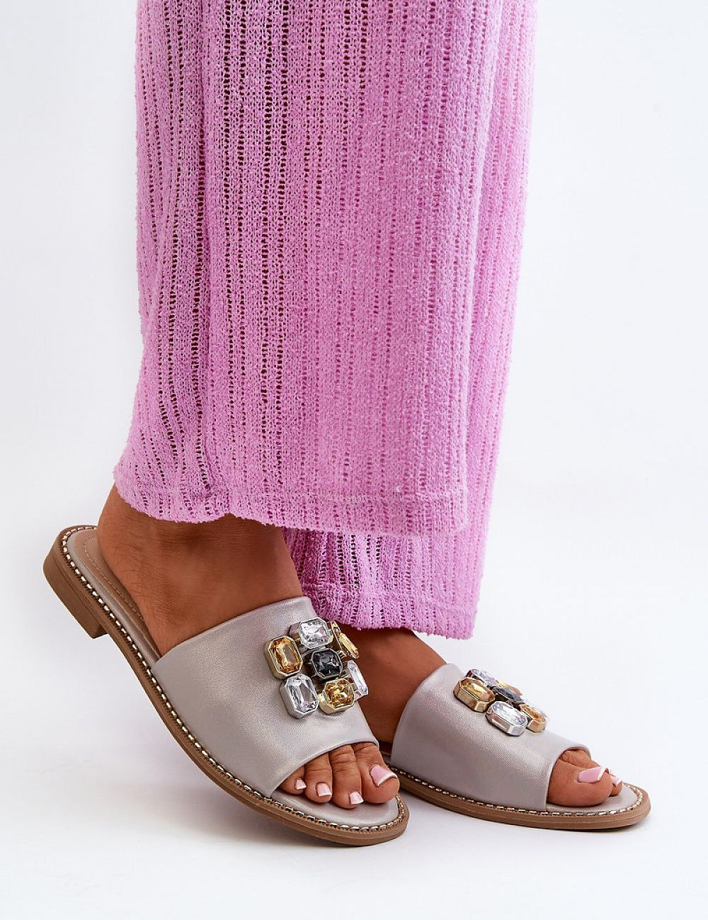 Elegant Velinor Decor Flat Sandals with glossy synthetic upper and decorative accents, worn with pink textured pants.