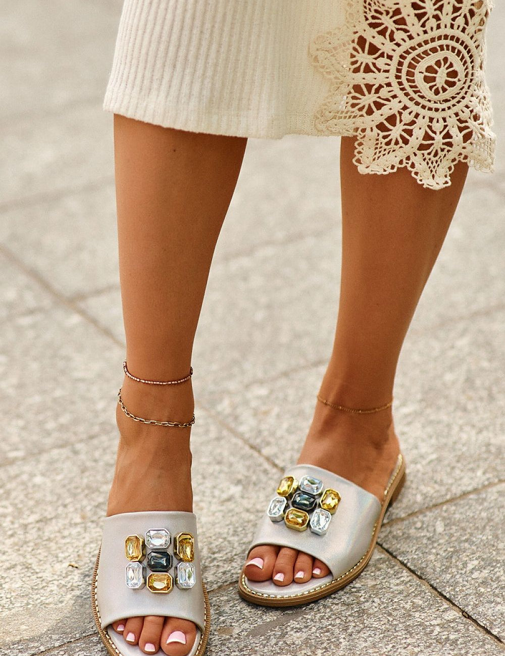 Model wearing Velinor Decor Flat Sandals with decorative accents and leather insole, perfect for summer styling.