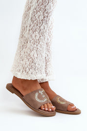 Person wearing Naerelle Suede Flip-Flops with sequin detail, paired with lace pants, highlighting casual summer style.