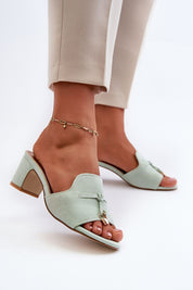 Woman wearing Solvera heeled suede flip-flops with a 5.5 cm heel, showcasing minimalist design and eco-suede finish, stylish and comfortable.