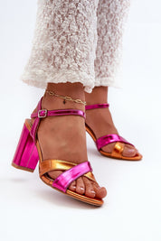 Colorful cross-strap heeled sandals with pink and orange metallic finish, featuring a block heel and ankle bracelet detail.