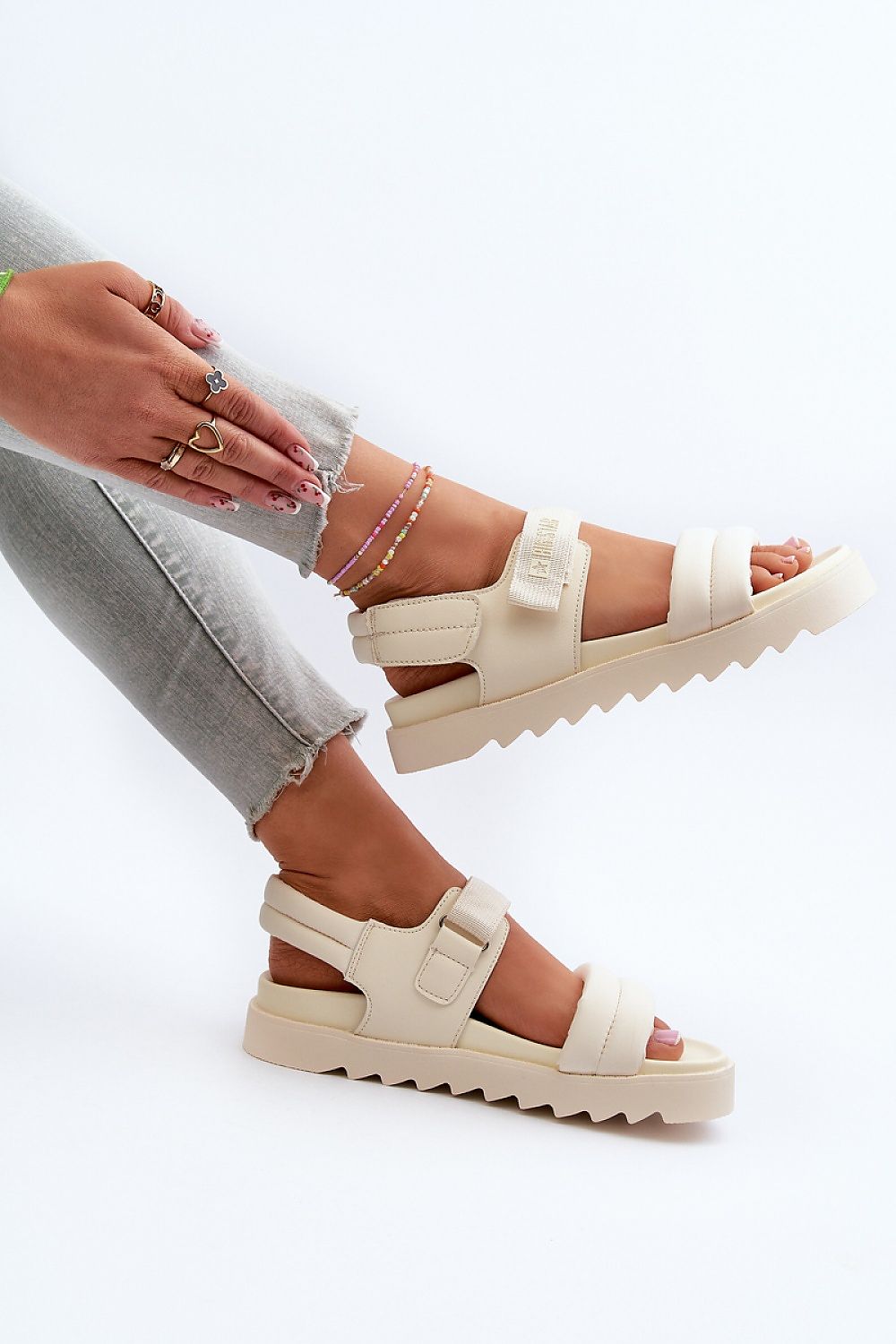 Alt Tag: Woman wearing cream Rivexa platform strap sandals with eco leather, paired with gray jeans and anklets, highlighting comfort and style.