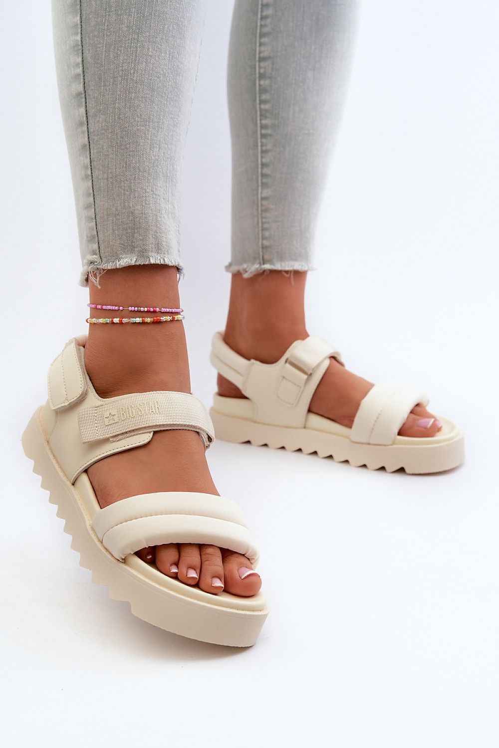 Woman wearing Rivexa Platform Strap Sandals with Velcro closure and platform sole, showcasing comfort and style in cream color.