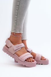 Person wearing pink Rivexa Platform Strap Sandals with Velcro fastening and platform sole, paired with denim jeans.