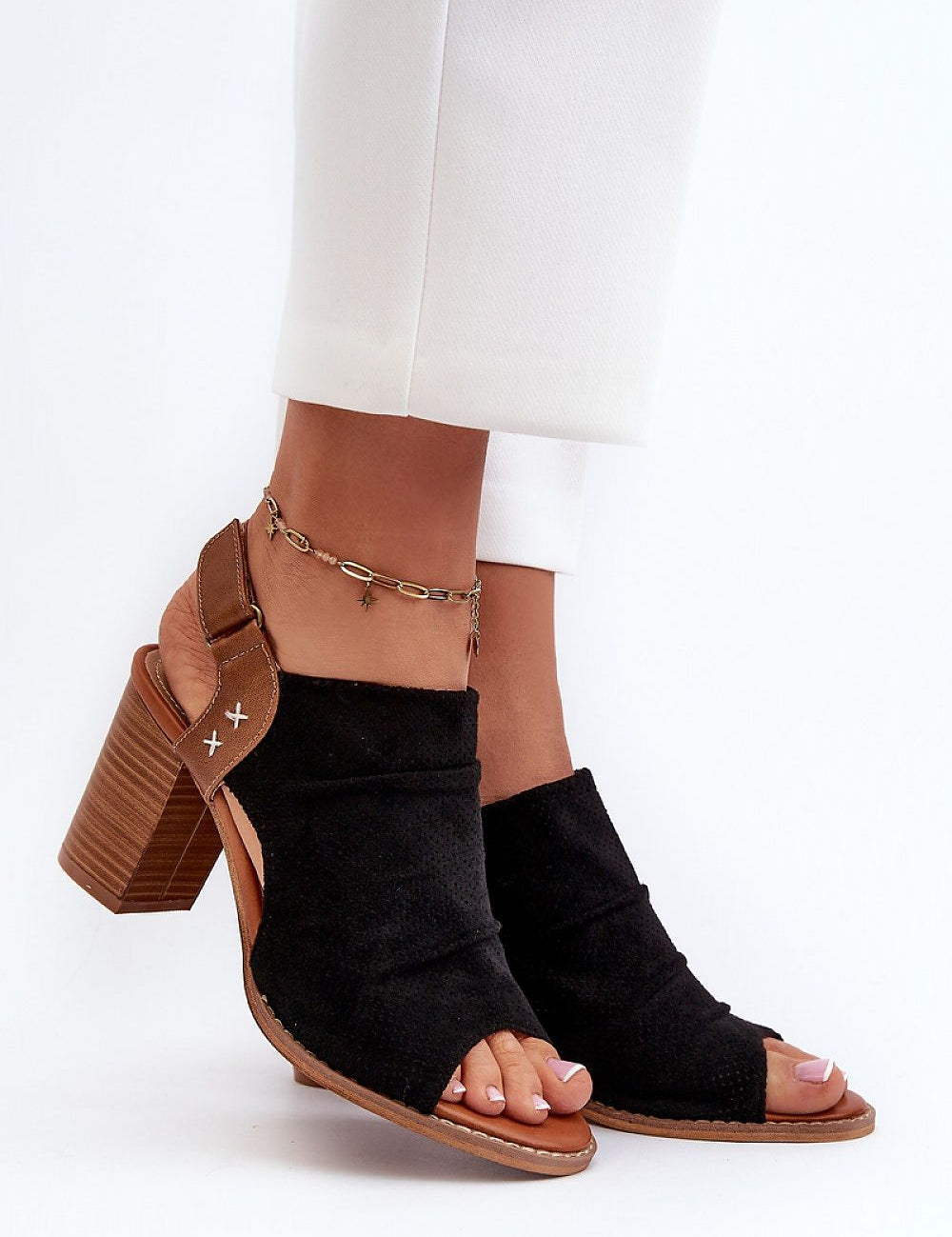 Woman wearing Veliera Suede-Cutout Sandals with high heels and velcro closure, showcasing eco-suede texture and natural leather insole.