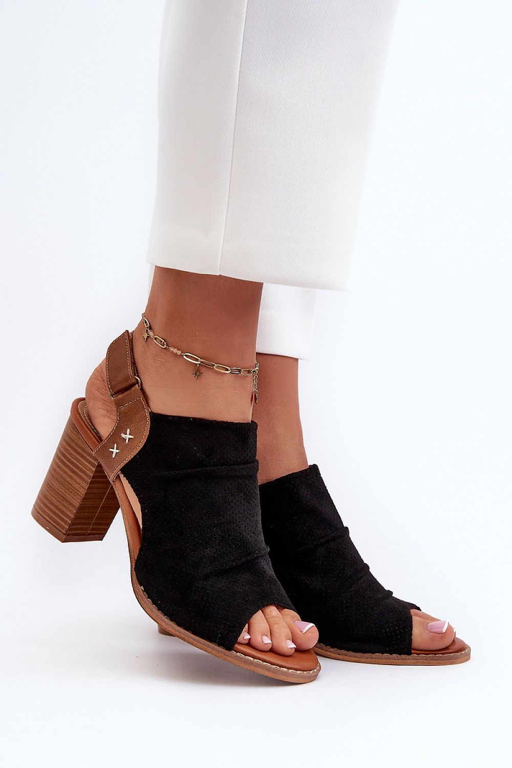 Woman wearing Veliera Suede-Cutout Sandals with high heels and velcro closure, showcasing eco-suede texture and natural leather insole.