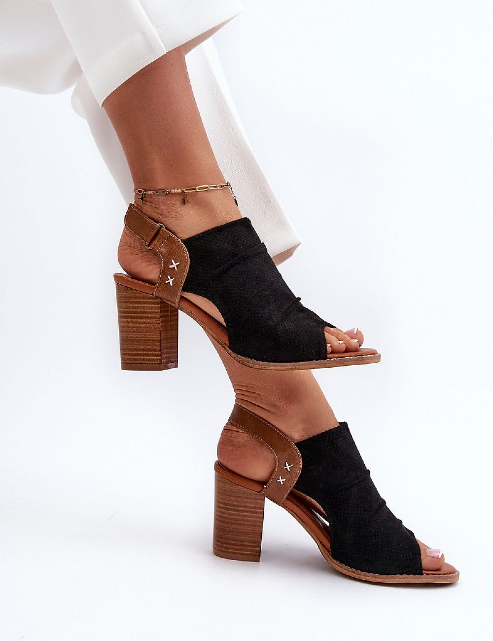 Woman wearing Veliera suede-cutout high-heel sandals with a structured heel and elegant design, perfect for summer fashion.