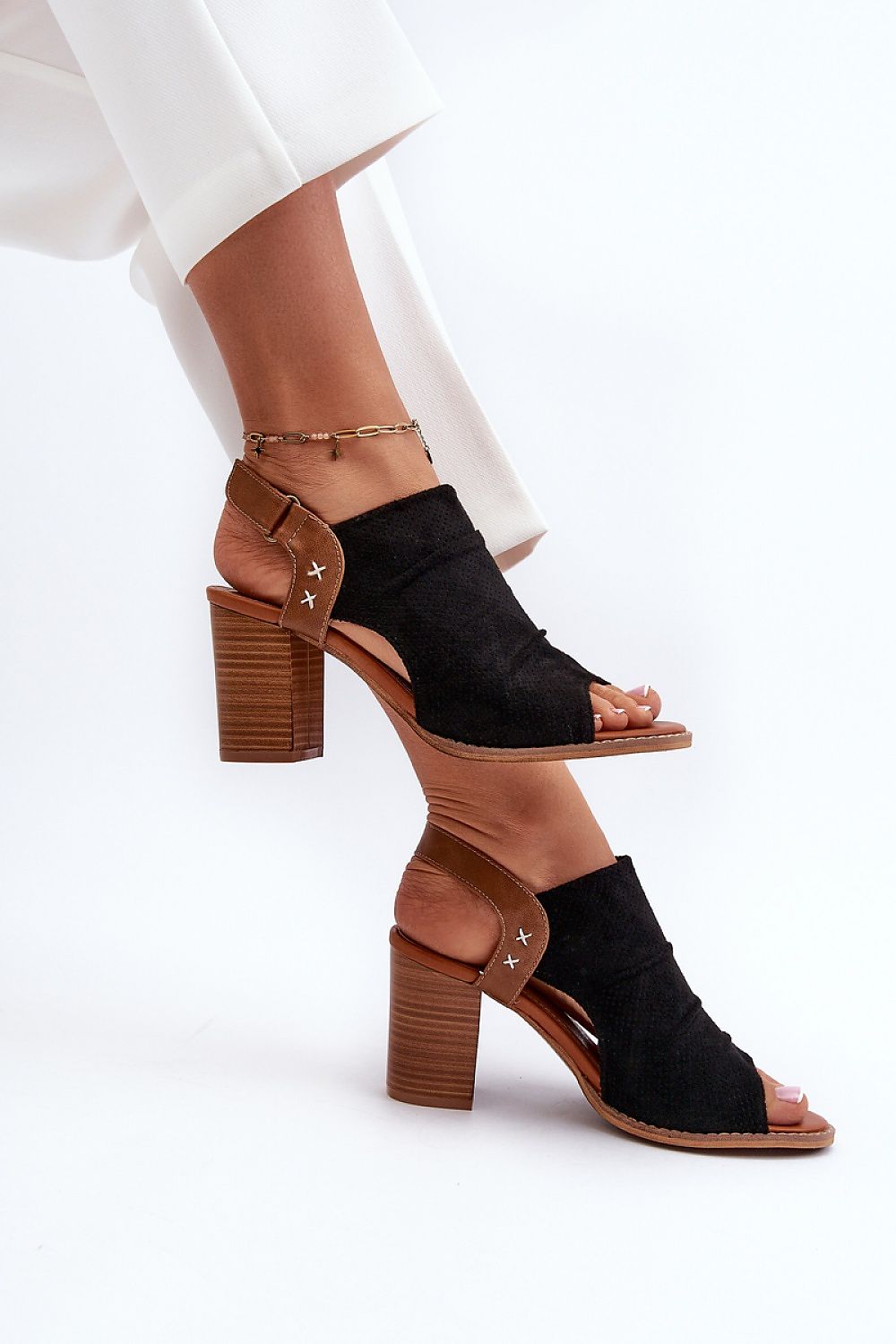Woman wearing Veliera suede-cutout high-heel sandals with a structured heel and elegant design, perfect for summer fashion.