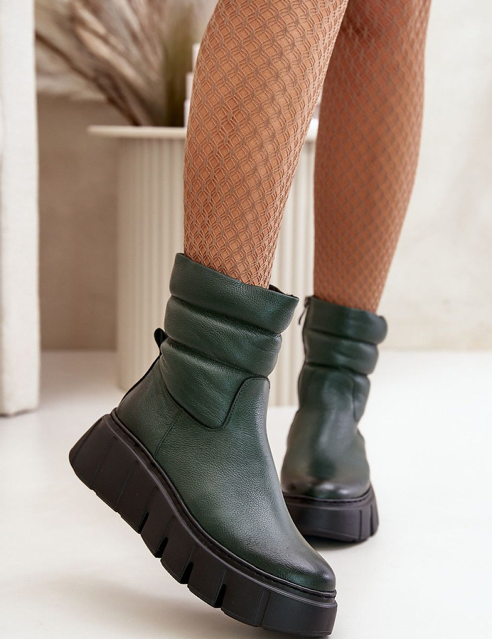 Green Orravelle Risefold Leather Balance ankle boots with wedge platform, worn by a model in textured tights against a neutral backdrop.