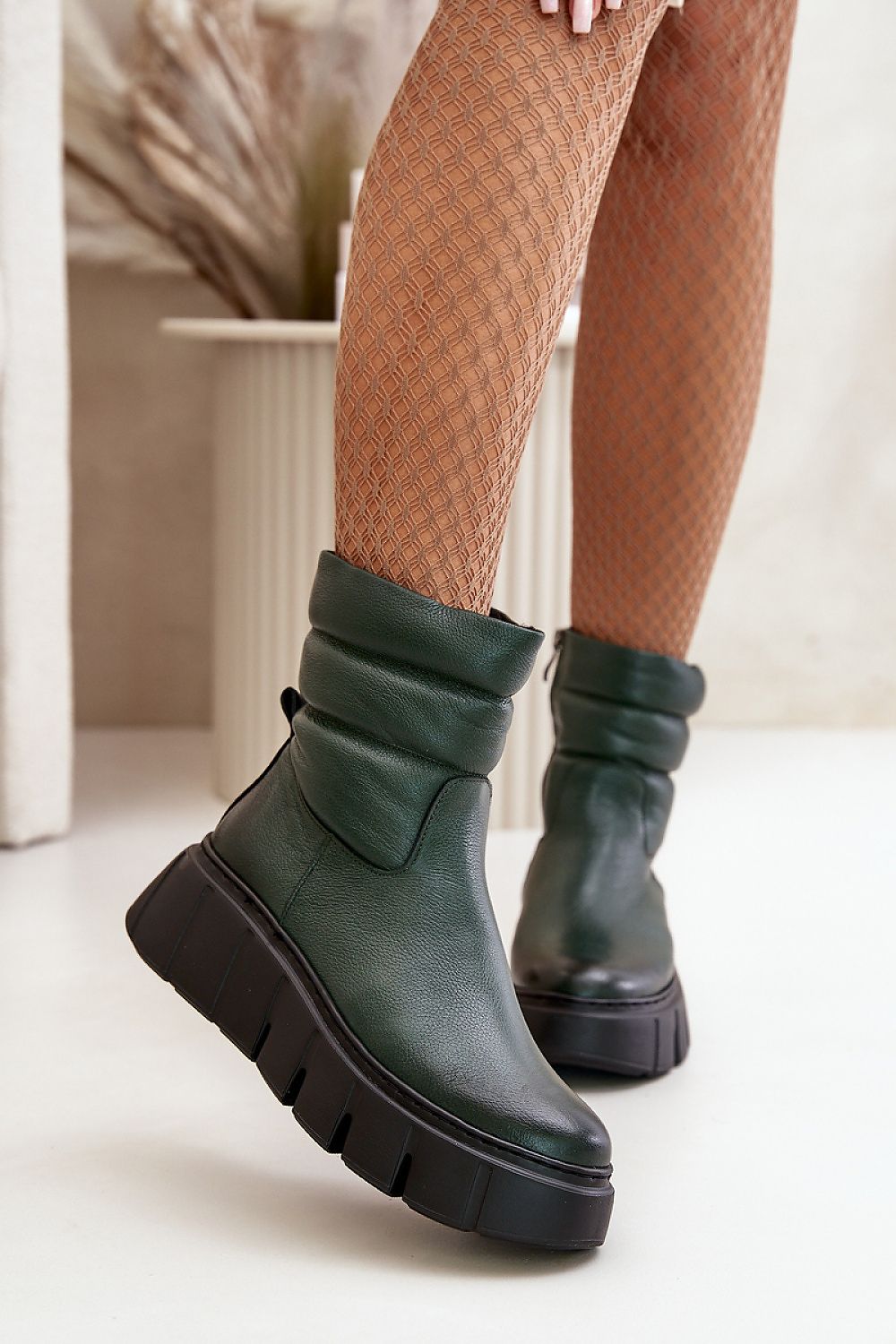 Green Orravelle Risefold Leather Balance ankle boots with wedge platform, worn by a model in textured tights against a neutral backdrop.