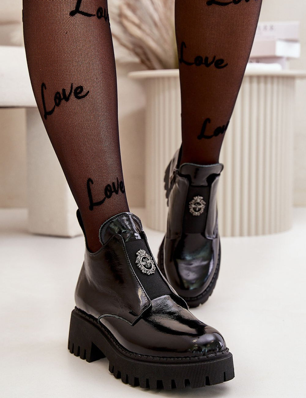 Virelsa Cresthold Leather Form ankle boots with chunky heel and sculptural embellishment, worn with 'Love' patterned tights.