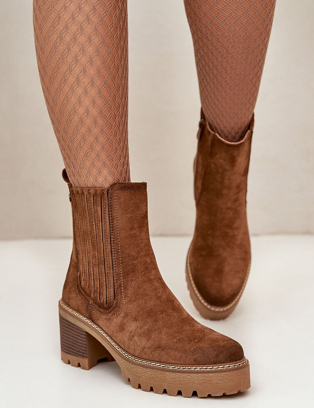 Suede-finish ankle boots with block heel, rounded toe, and discreet zipper. Perfect balance of elegance and comfort for all occasions.