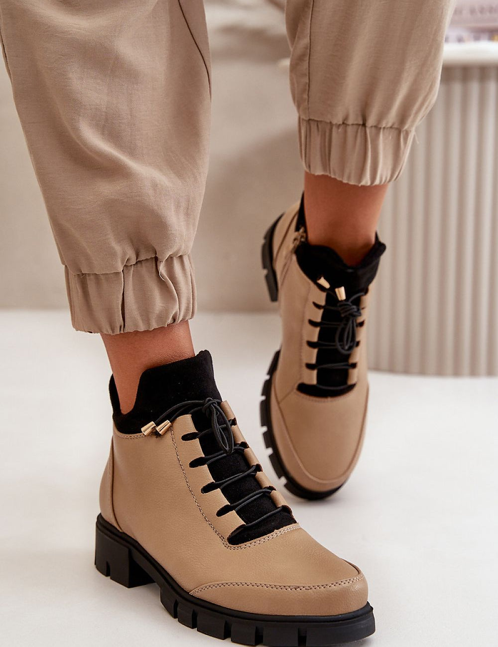 Narella Softcord Urban Base ankle boots in eco leather with black laces and side zipper, worn with beige pants.