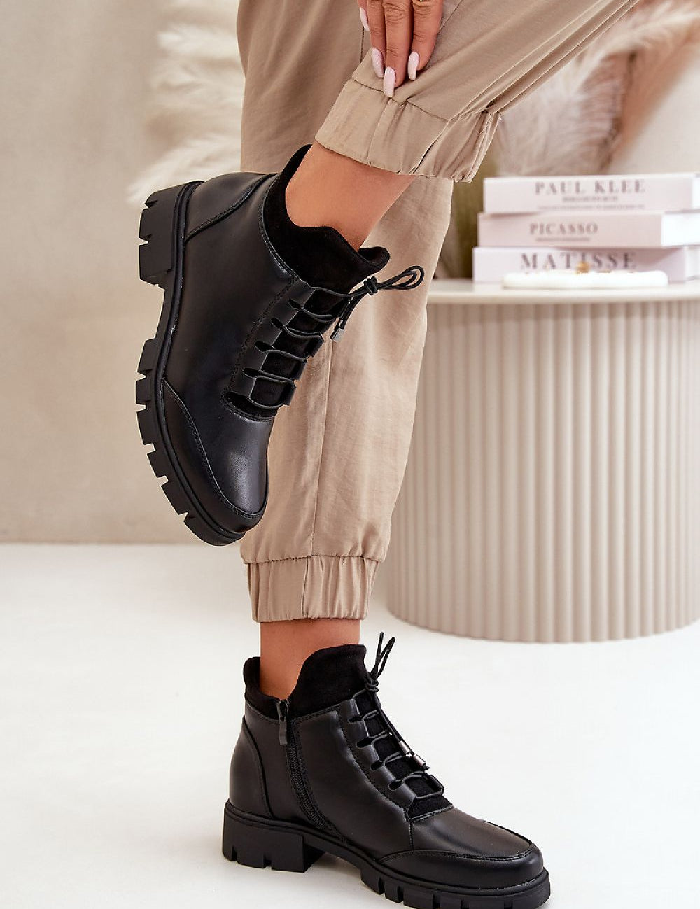 Narella Softcord Urban Base ankle boots in black eco leather with lacing and side zipper, styled with beige pants.