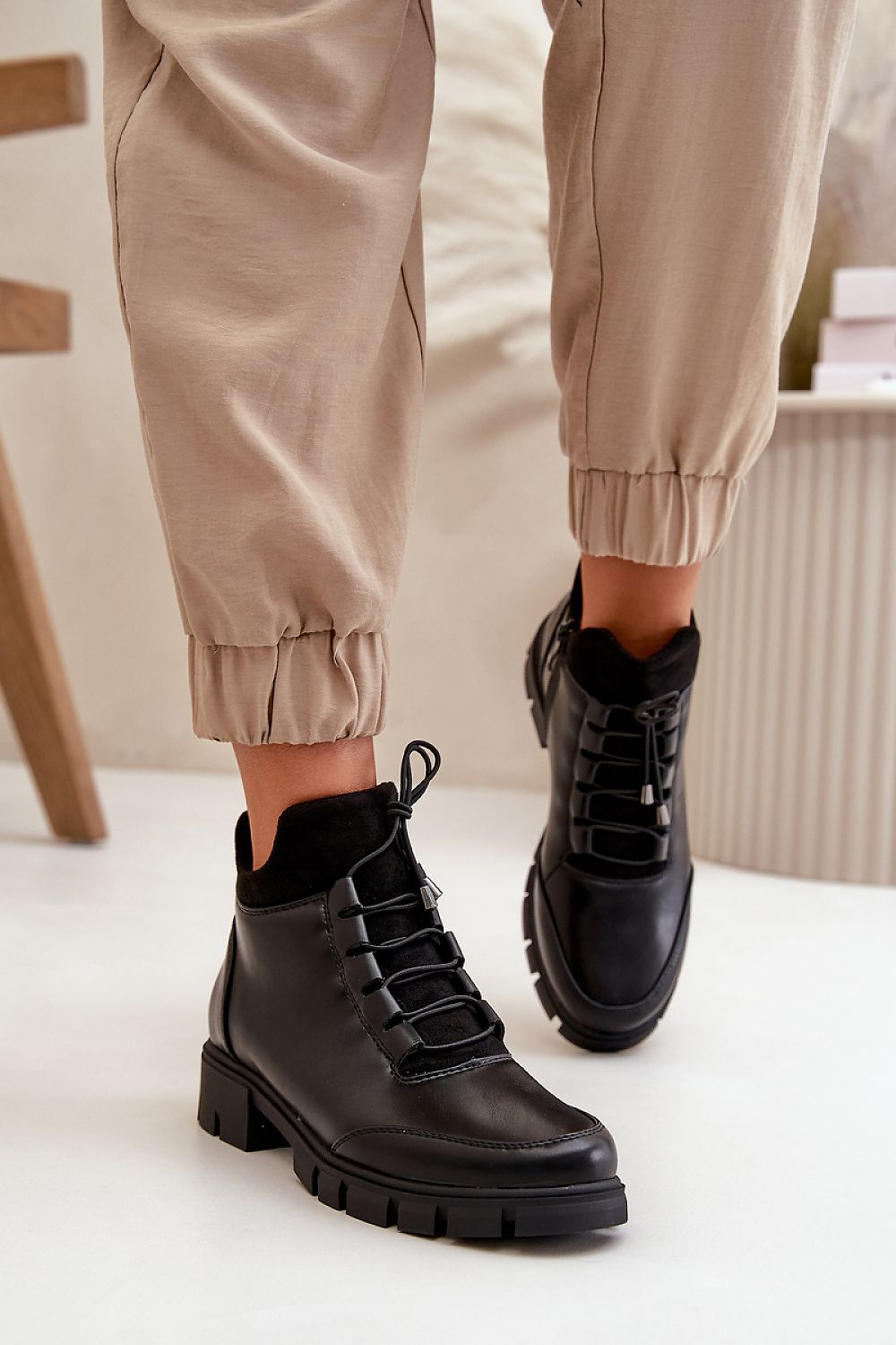 Narella Softcord Urban Base ankle boots in black eco leather with classic lacing and side zipper, paired with beige pants.