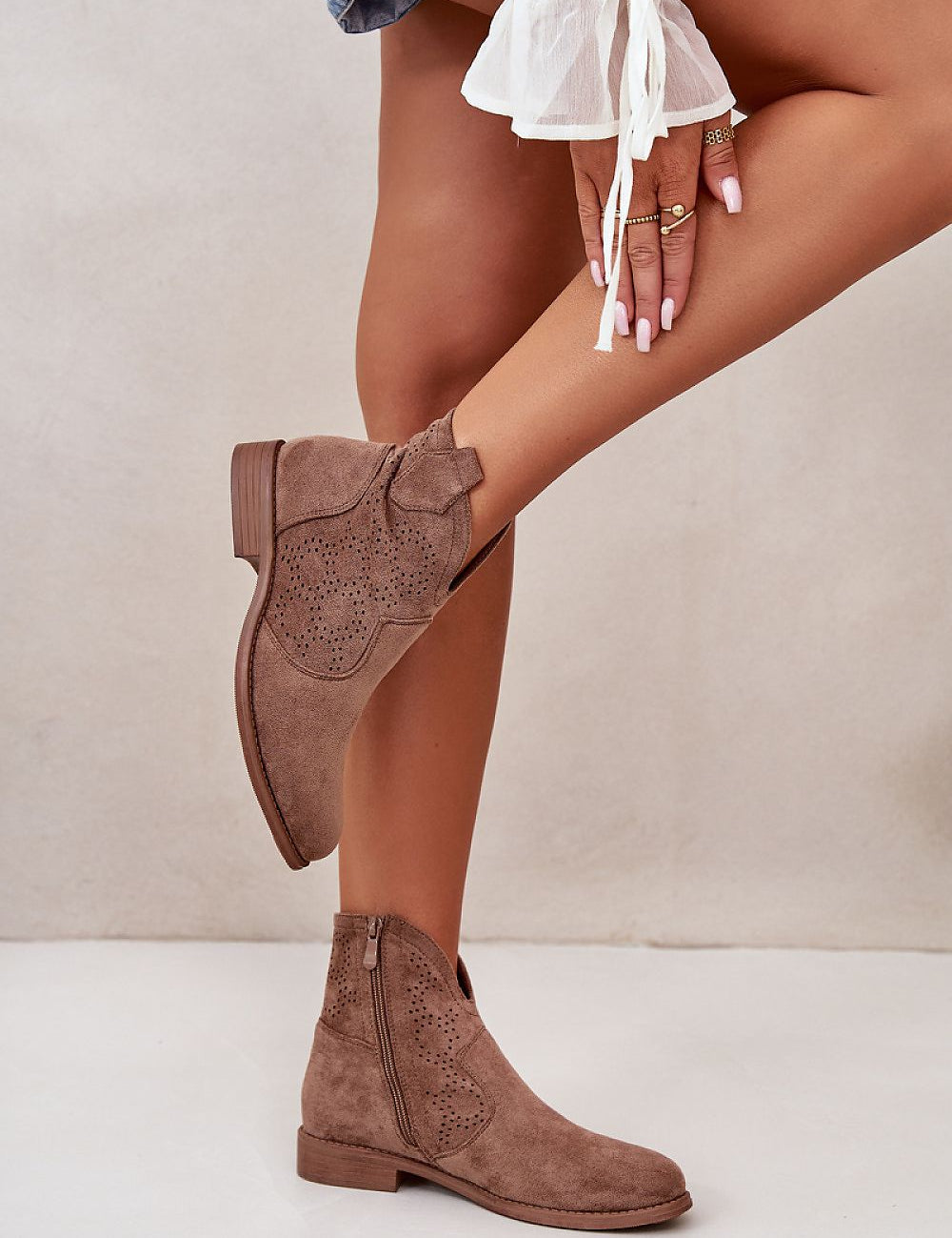 Woman wearing Eliavine Laceshade Spring Ease ankle boots in eco suede with lace-inspired design and flat heel, side view.