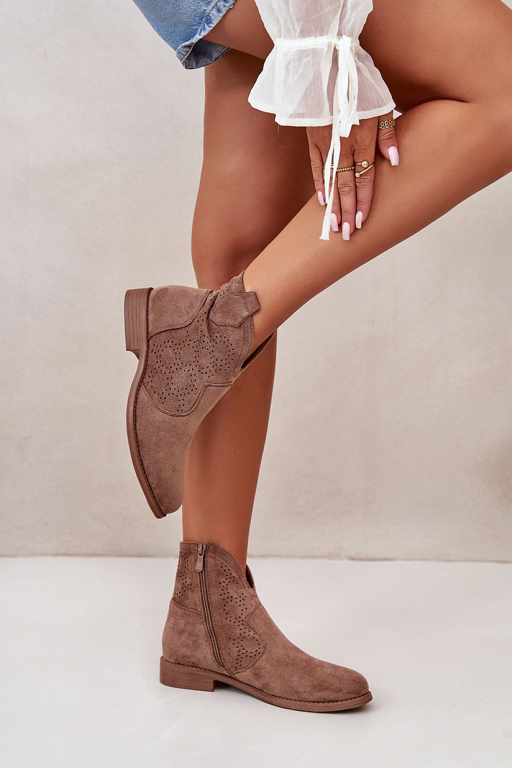 Woman wearing Eliavine Laceshade Spring Ease ankle boots in eco suede with lace-inspired design and flat heel, side view.