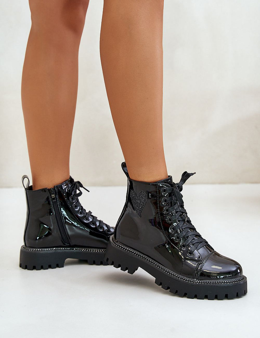 Shiny black ankle boots with side zipper and lace-up front, featuring a glitter heart embellishment and rhinestone trim.