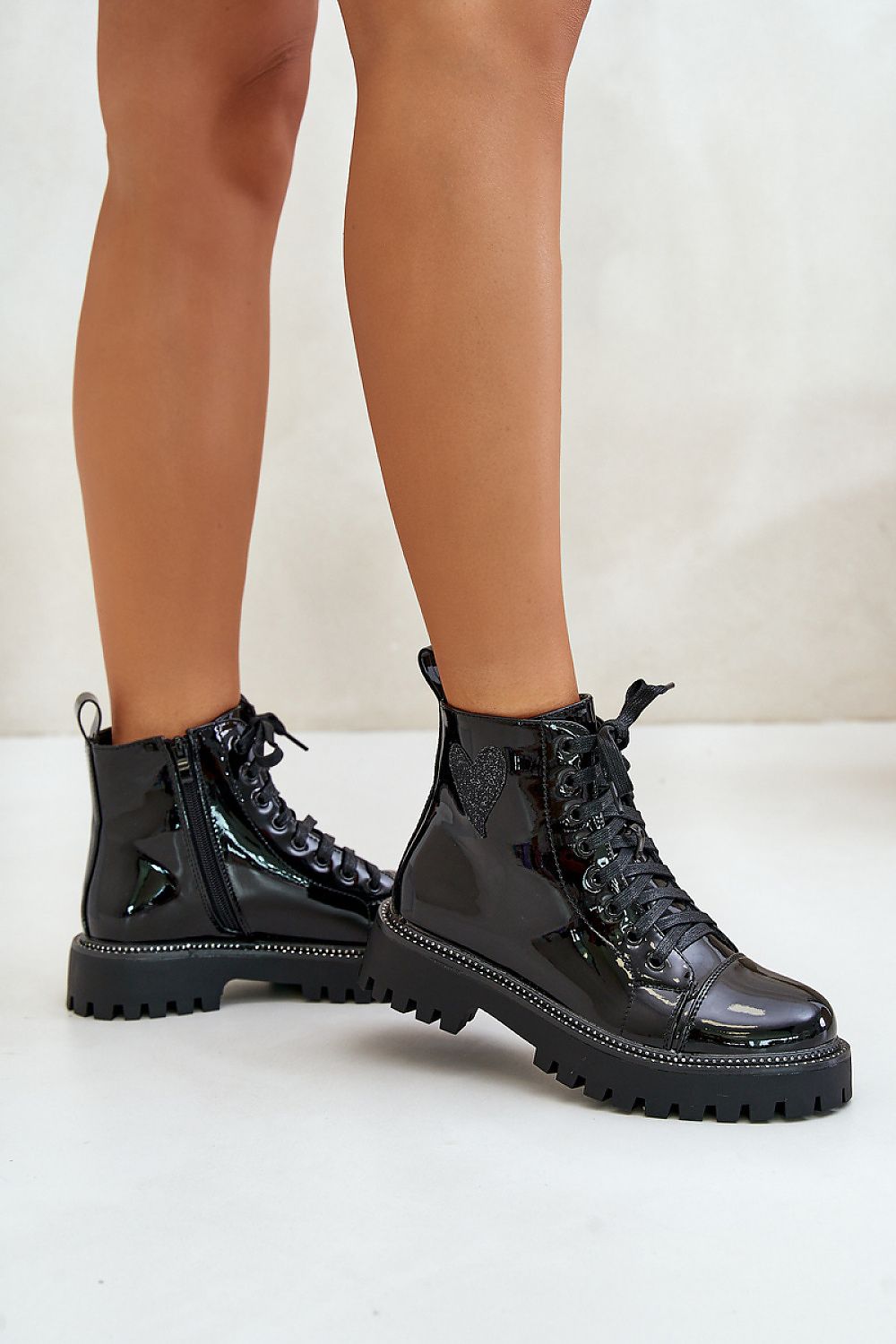 Shiny black ankle boots with side zipper and lace-up front, featuring a glitter heart embellishment and rhinestone trim.