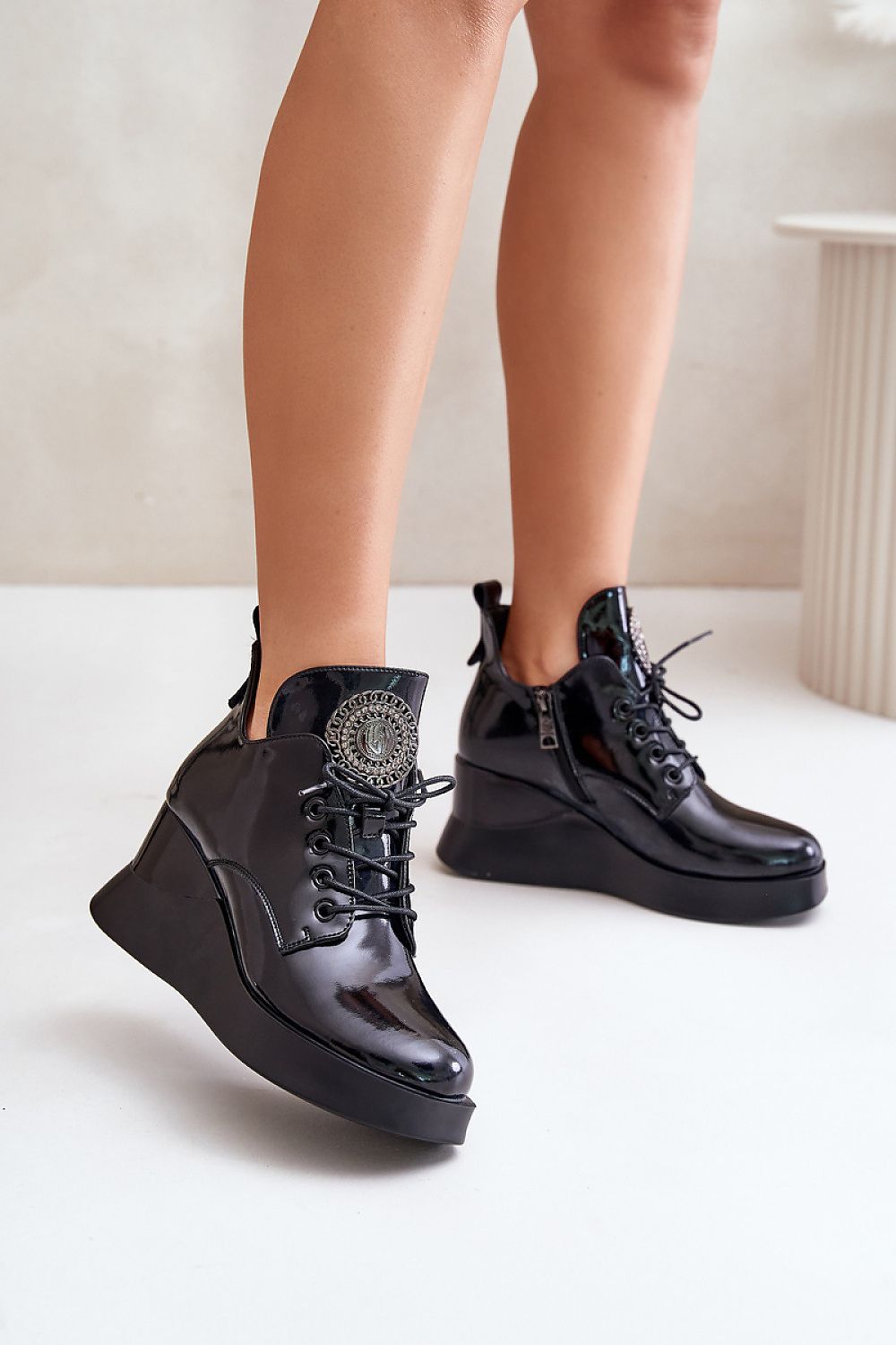 Elegant Tavendra platform boots with sleek natural leather, bold block heel, side zipper, and unique tongue embellishment.