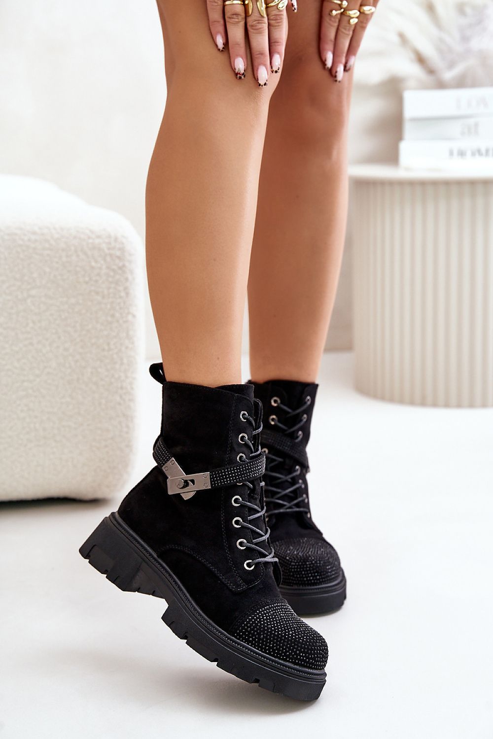 Model wearing black Lindrava Cozy Suede Winter Boots with lace-up design and flat heel, styled with a decorative buckle and soft lining.