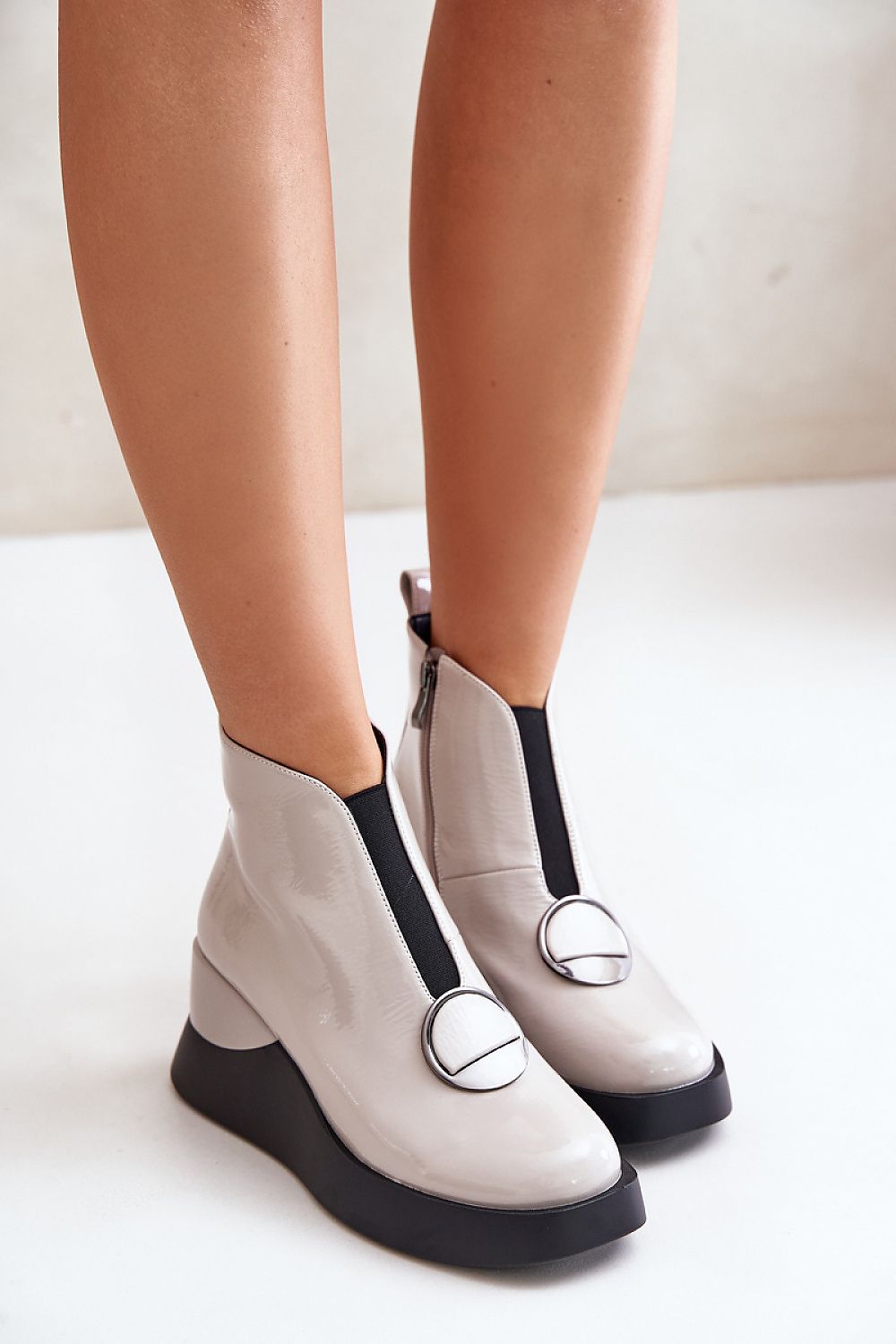 Bravina platform ankle boots in sleek eco leather with side zipper and ornamental detail, offering height and comfort for cold-weather fashion.